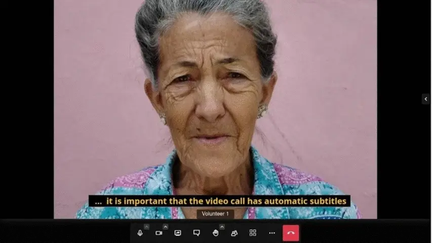 Jitsi Meet videoconference with the participant on screen, a yellow caption ribbon reading 'it is important that the video call has automatic subtitles', and the full call-control bar at the bottom